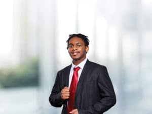 Formally dressed black male with red tie in business school setting