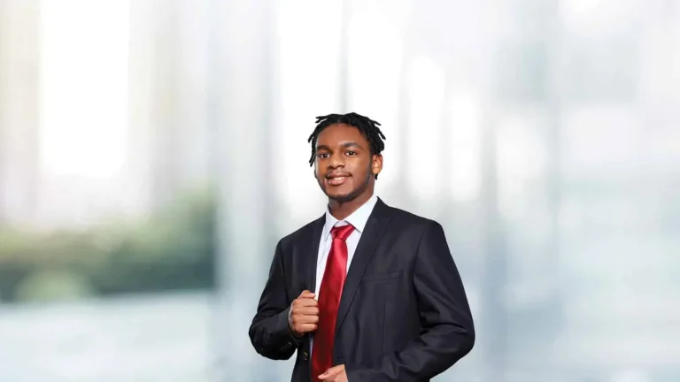Formally dressed black male with red tie in business school setting