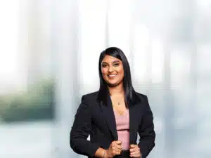 A businesswoman dressed in professional attire within a business school environment.