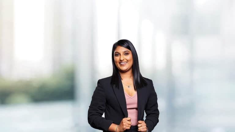 A businesswoman dressed in professional attire within a business school environment.